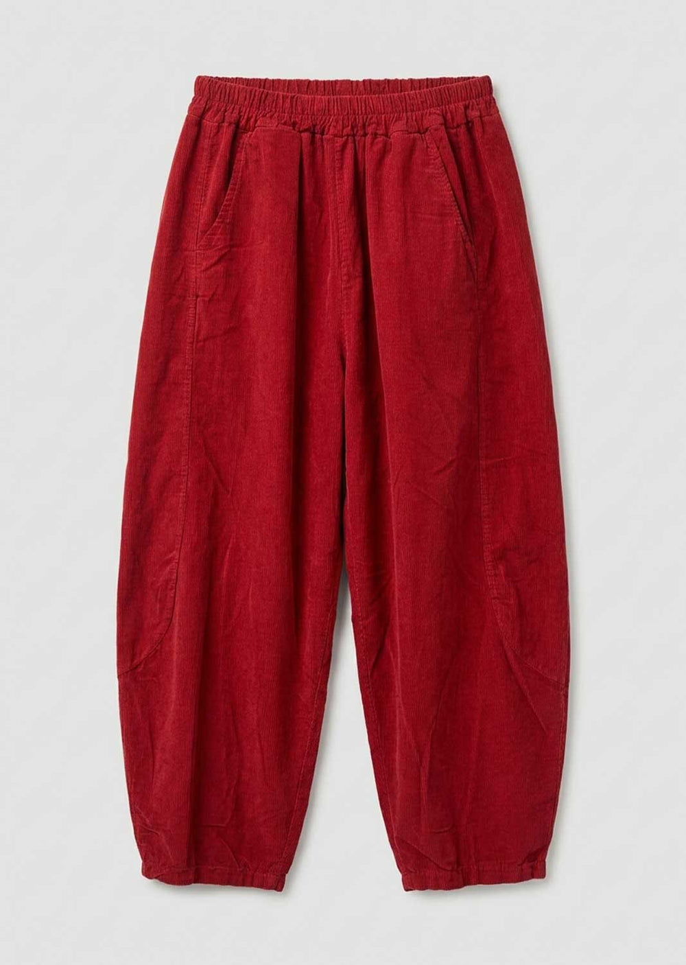 Red needlecord barrel leg pants with an elastic waistband and side pockets, laid flat on a light gray background.