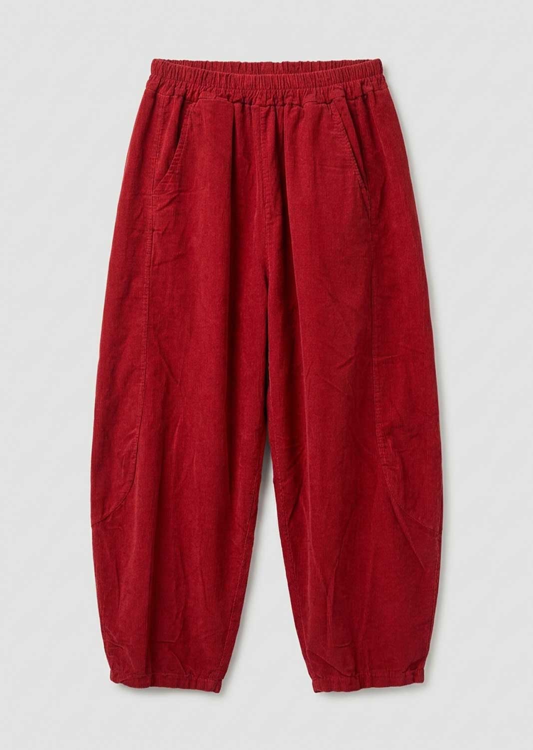 Red needlecord barrel leg pants with an elastic waistband and side pockets, laid flat on a light gray background.