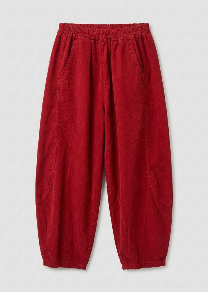 Red needlecord barrel leg pants with an elastic waistband and side pockets, laid flat on a light gray background.
