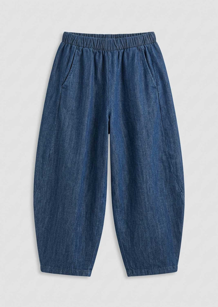 A pair of loose-fitting blue denim barrel pants with an elastic waistband and side pockets, displayed flat against a light gray background.