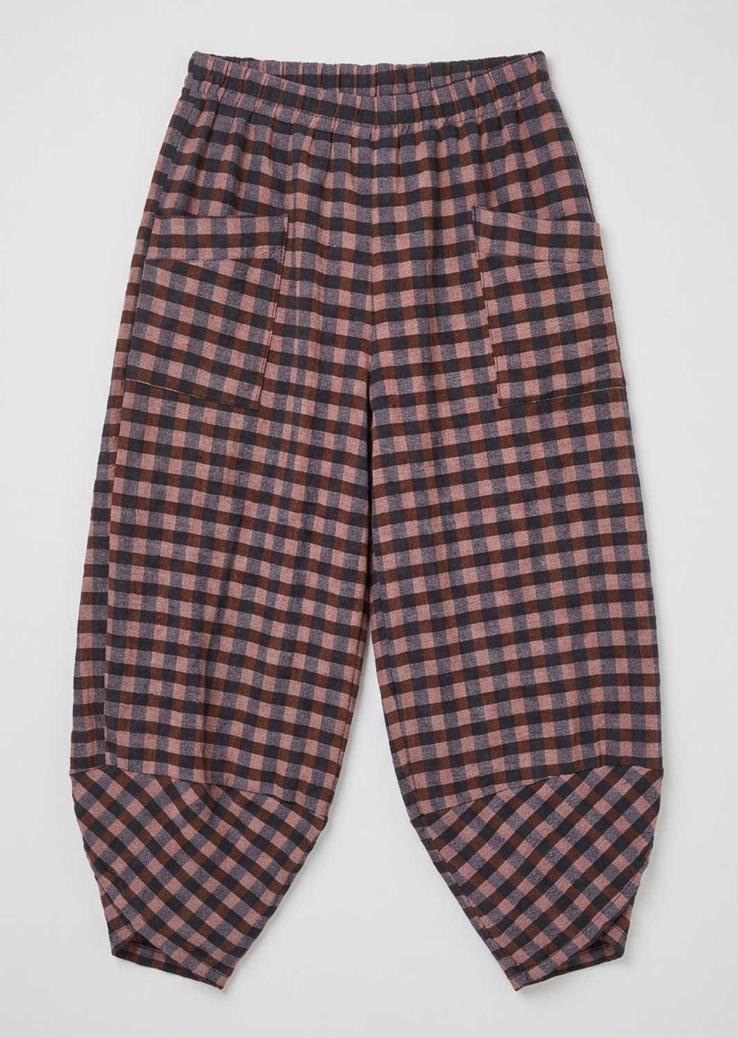 A pair of loose-fitting pants with an elastic waistband and a pink and black checkered pattern, laid flat against a light gray background.