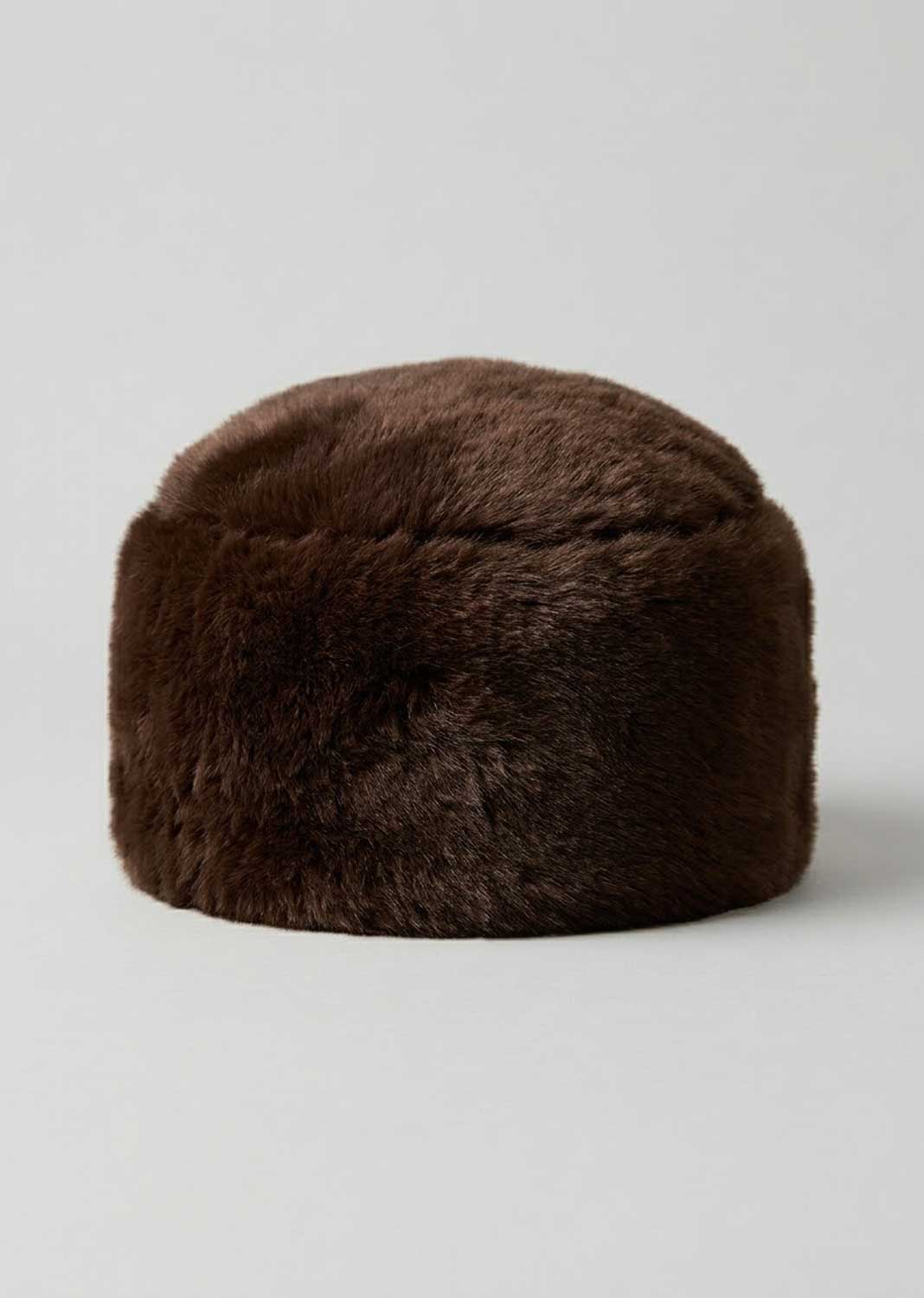 A dark brown faux fur hat with a rounded, slouchy shape, photographed against a neutral light gray background.