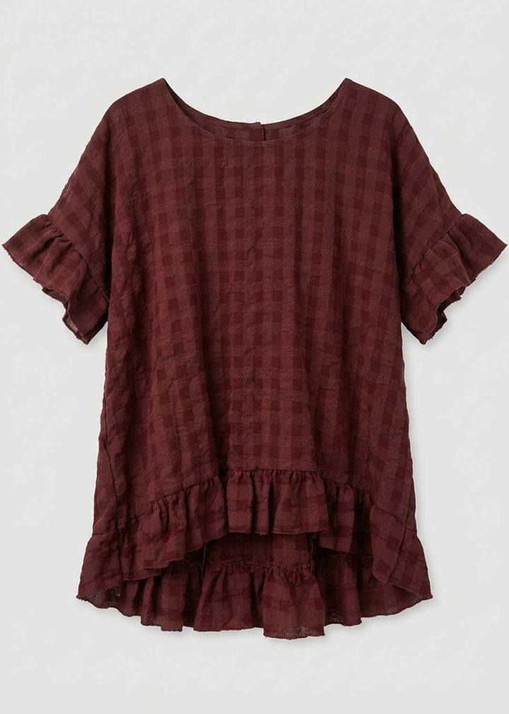 A dark burgundy plaid short-sleeve top with ruffled sleeves and a tiered ruffle hem, displayed flat against a light gray background.