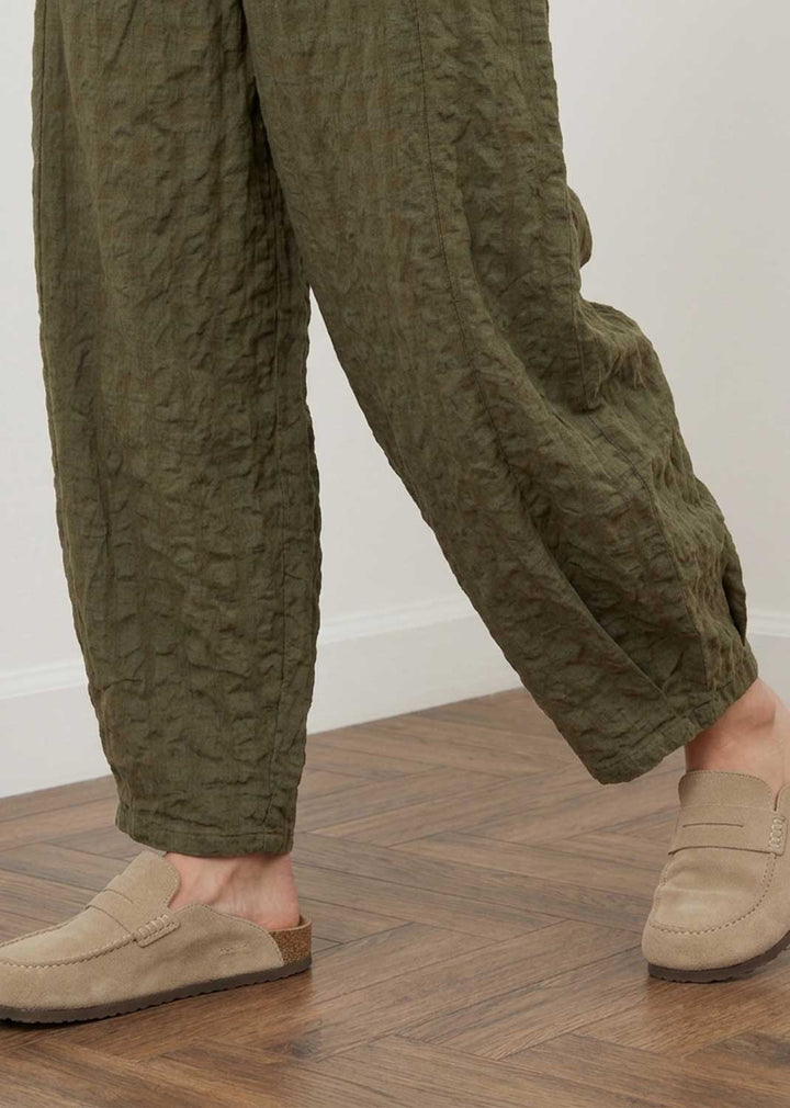 Olive green textured crinkled wide-leg pants shown on a model&