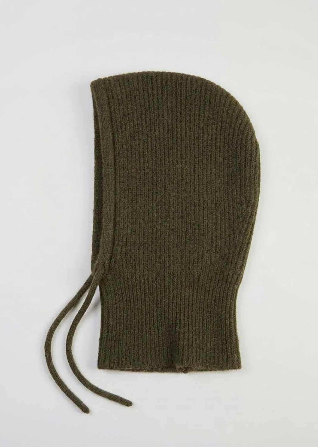 An olive green ribbed knit bonnet with drawstrings, laid flat on a light gray background.