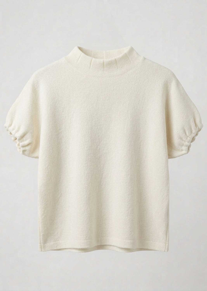 An off-white short-sleeve knit top with a mock neck and gathered puff sleeves, displayed against a light gray background.