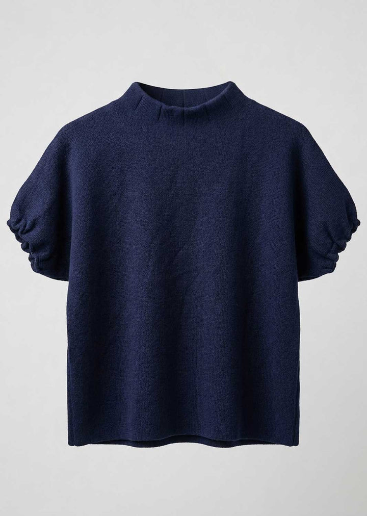 A navy blue knit top with a mock neck and voluminous elbow-length puff sleeves, shown against a light gray background.