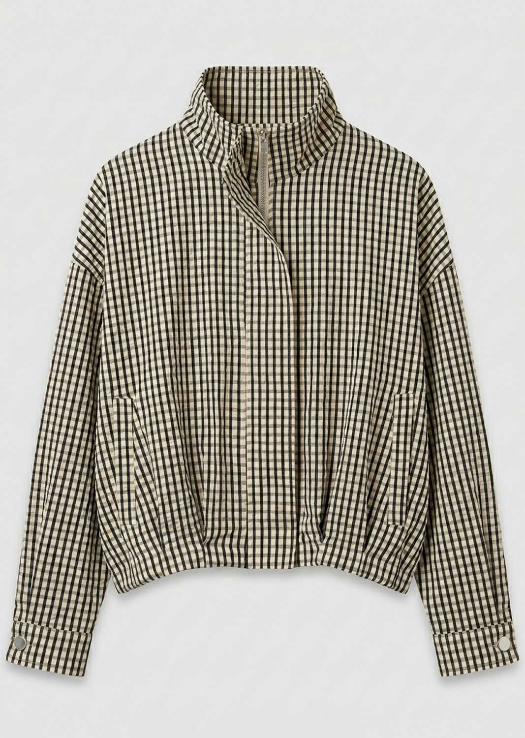A cropped long-sleeve jacket with a high stand-up collar and an asymmetrical zipper closure, featuring a black and beige gingham check pattern, shown against a plain light gray background.