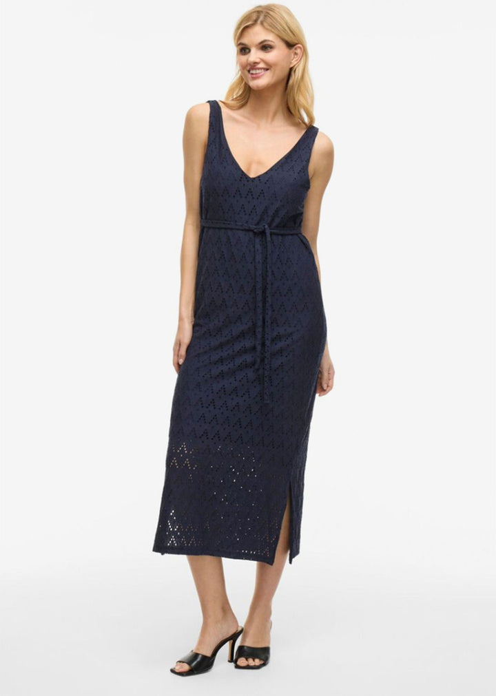 Woman wearing a navy lace dress on a white background