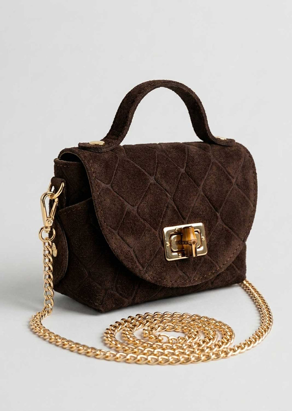 A dark brown croc suede suede handbag with a top handle, gold-tone clasp, and a coiled gold chain strap on a light gray background.